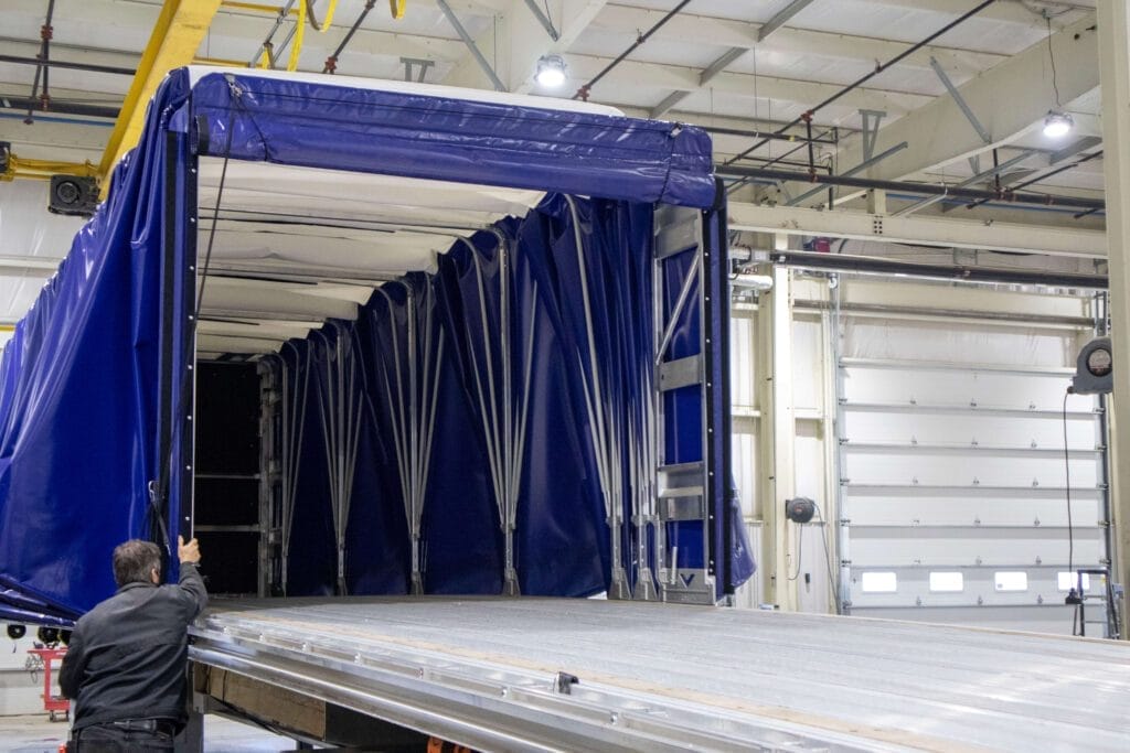 opening blue rolling tarp system flatbed from ground