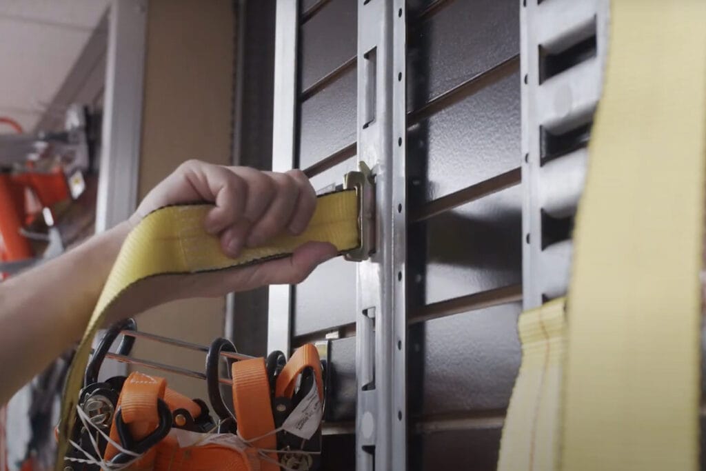 What is an E-Track System - yellow e strap being attached to an e track